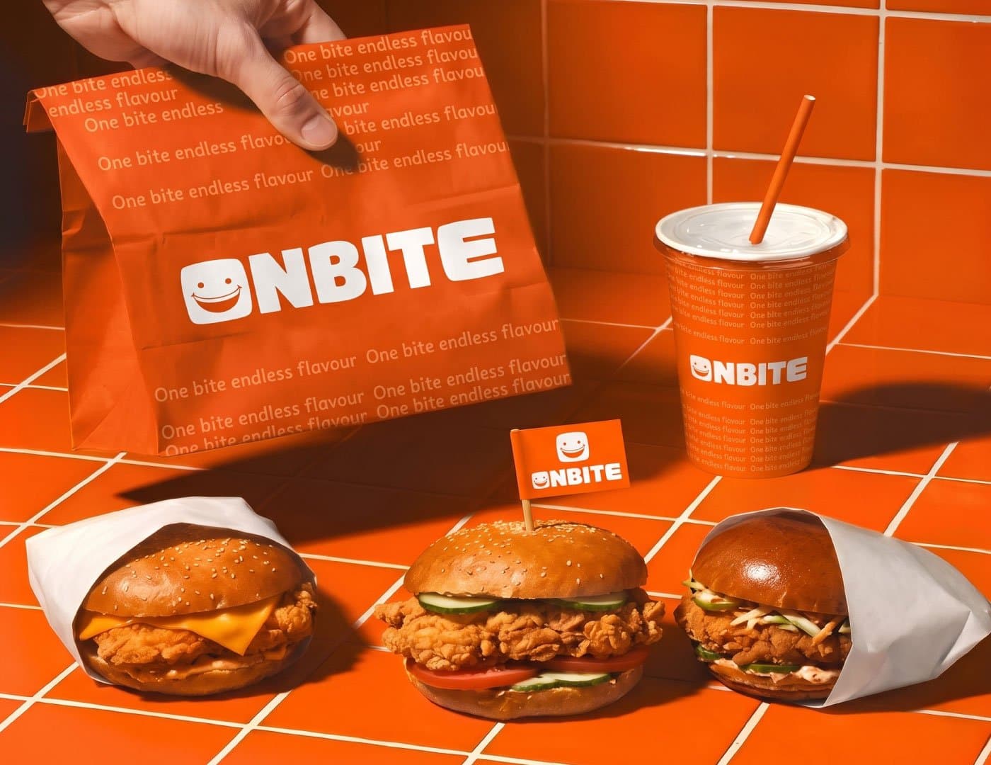 ONBITE food branding scene featuring branded takeaway bags, drinks, burgers, and orange restaurant visual identity