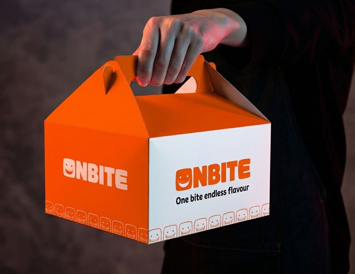 OnBite branded takeaway food box with orange and white packaging, logo, tagline, and signature smile pattern