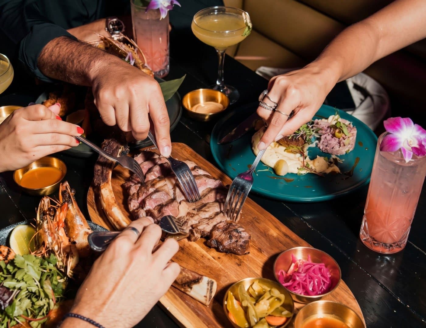 Social dining experience featuring grilled steak, seafood, cocktails, and shared dishes in an upscale restaurant setting.